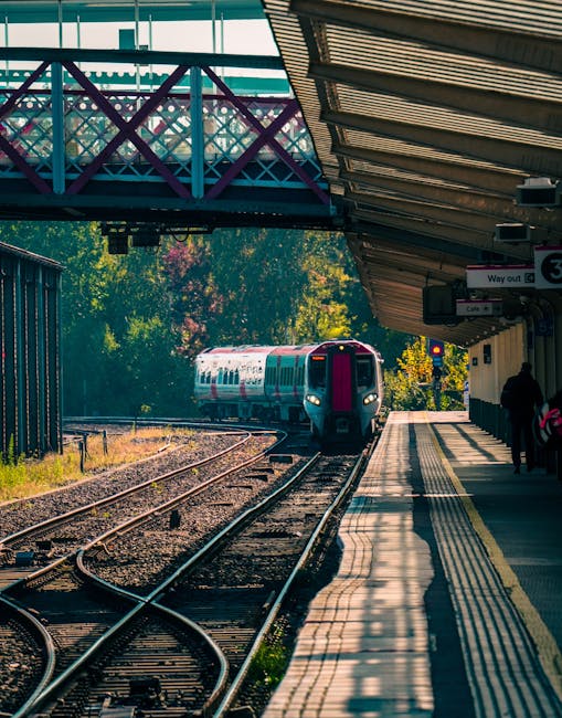 Photograph taken at Honor Oak Park Station showcasing a modern train arriving or departing along the railway tracks. The station platform is visible with a few passengers waiting, and the station’s